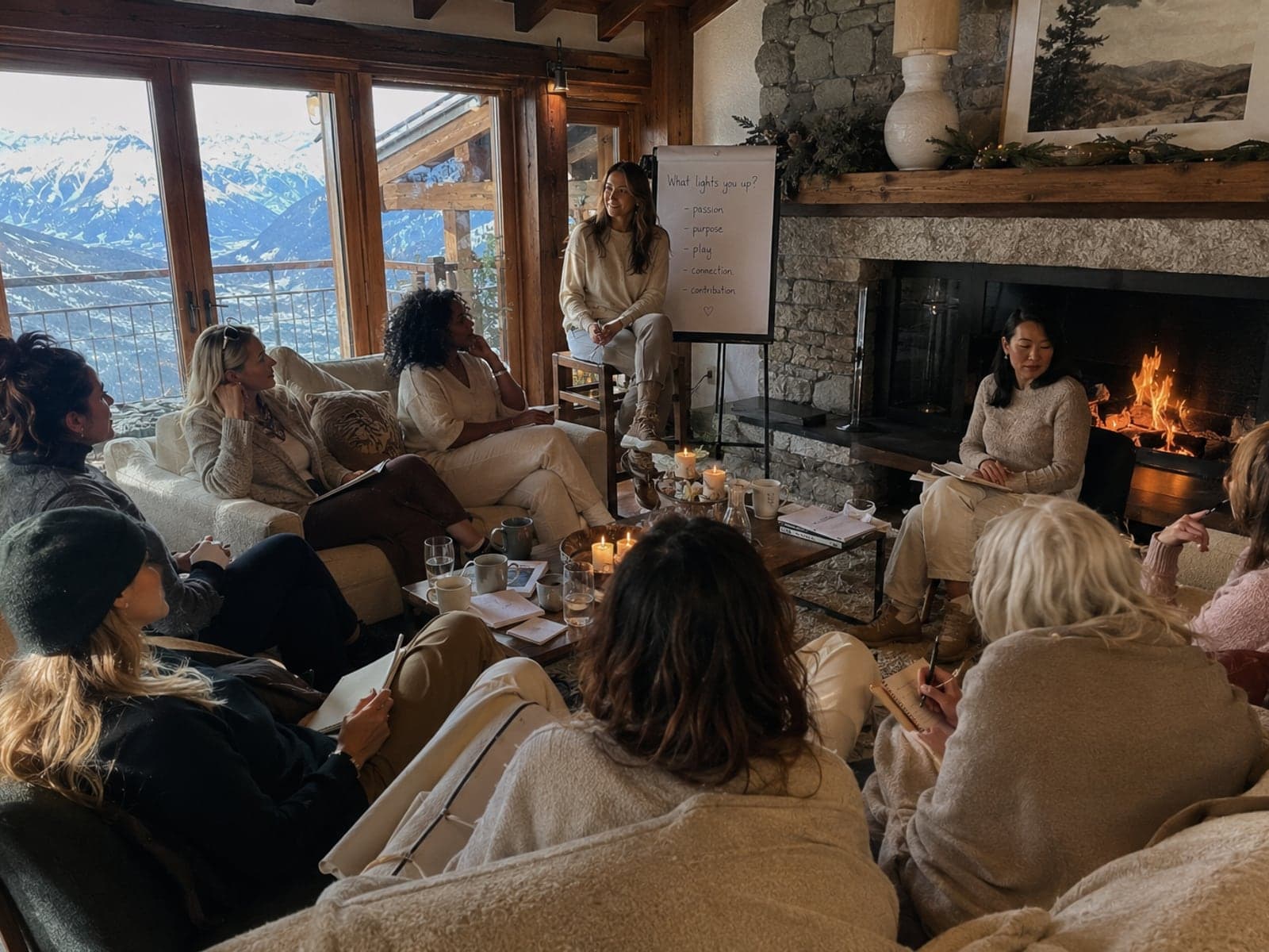 Women in a candlelit alpine chalet during a self-development workshop at a Body & Soul ski retreat.