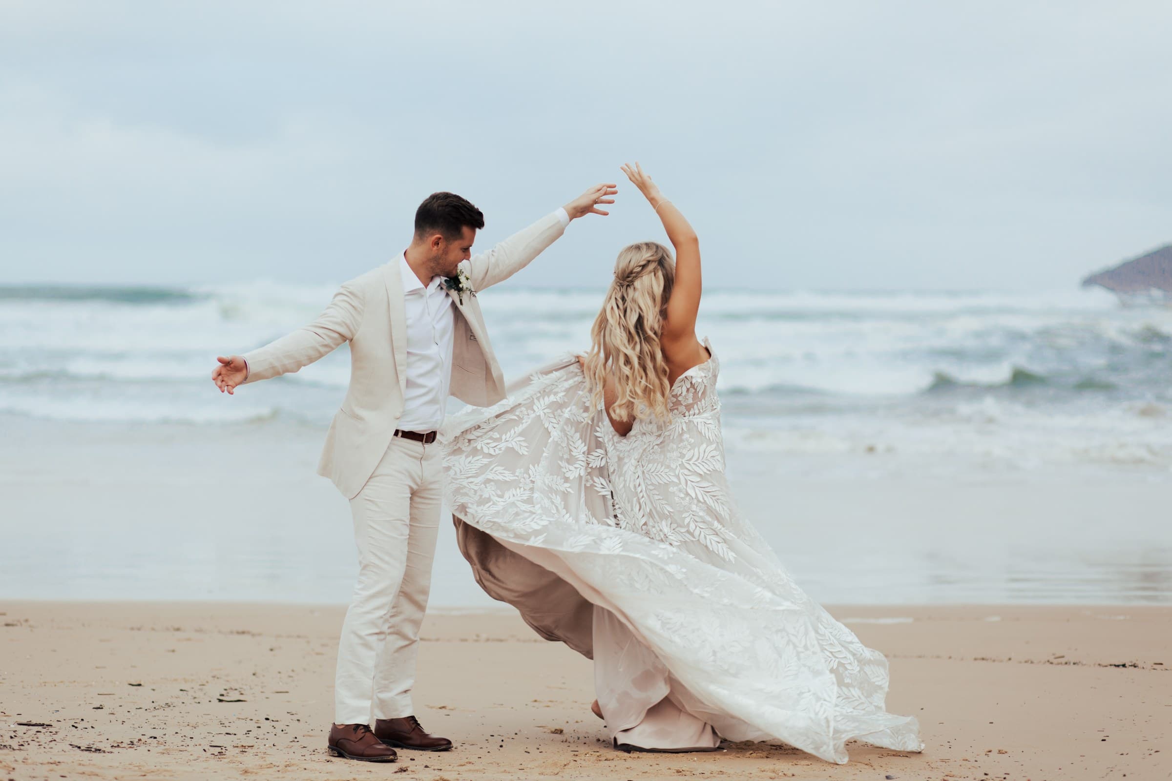 A couple dancing on the shore at their Body & Soul beach wedding.